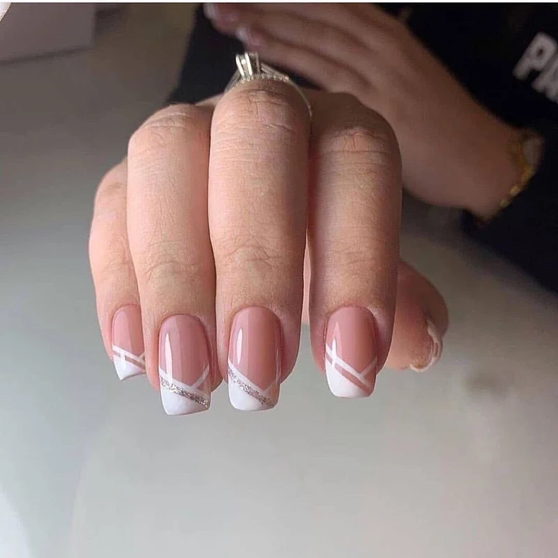 Kunstvolle Nageldesign mit elegantem French-Tip und Glitzerakzenten Karnz