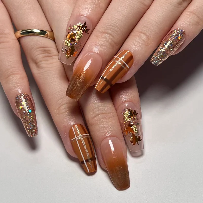 Kunstvolle Nagelverlängerungen mit Glitzer- und Blattmotiven Karnz