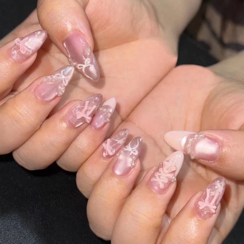 Kunstvolle Nagelverlängerungen mit zarten Schleifenmotiven Karnz