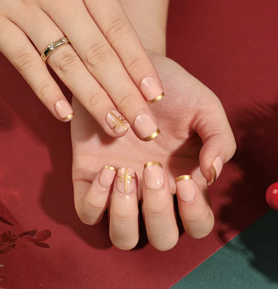 Elegante Kunstnägel mit goldenen Akzenten und floralem Design Karnz