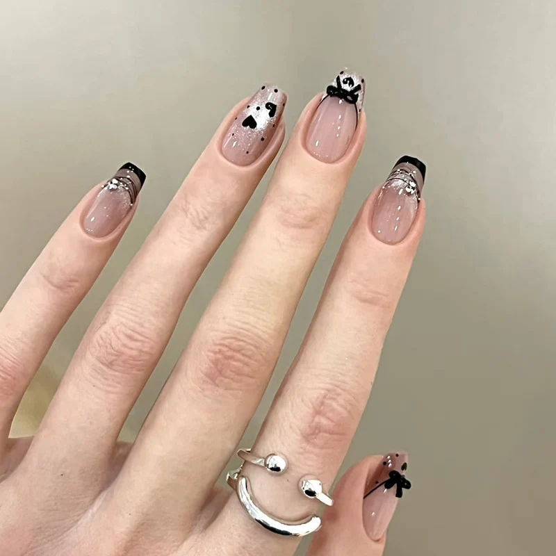 Elegantes kunstvolles Nageldesign mit Schleifen- und Glitzerelementen Karnz