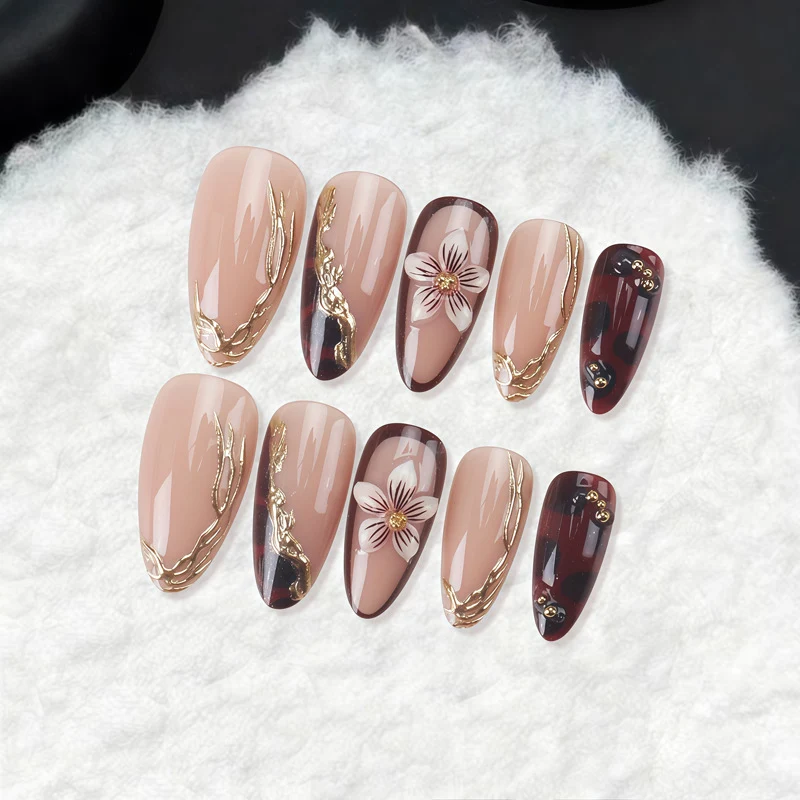 Dekorative Stiletto Press-On Nägel mit floralen und goldenen Akzenten Karnz