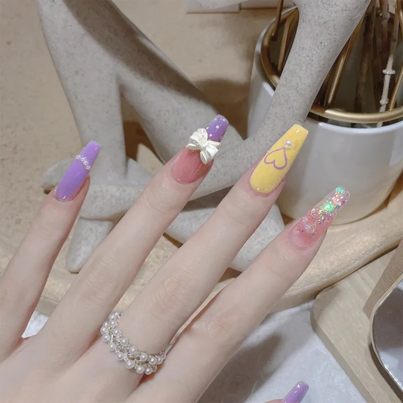 Kunstvolle Gel-Nägel mit elegantem Floral-Design und Glitzerakzenten Karnz