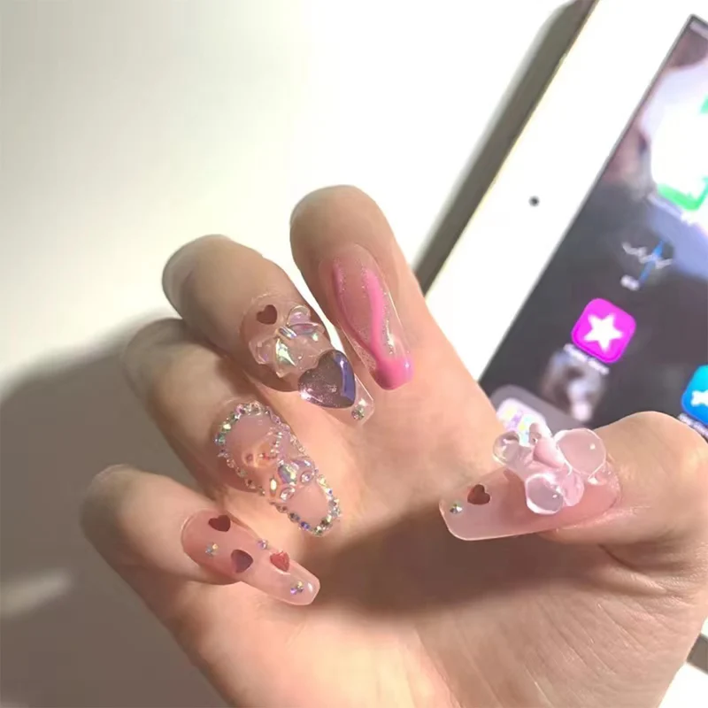 Kunstvolle Gel-Nägel mit elegantem Floral-Design und Glitzerakzenten Karnz