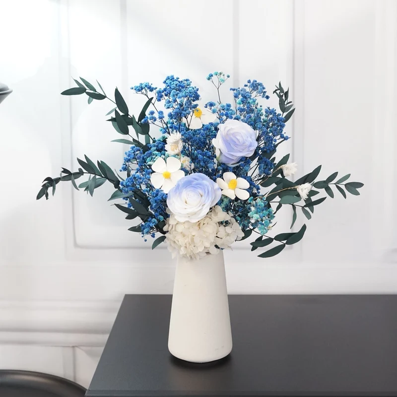 Künstliches Blumenarrangement mit dekorativer Vase