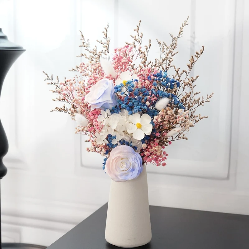 Künstliches Blumenarrangement mit dekorativer Vase
