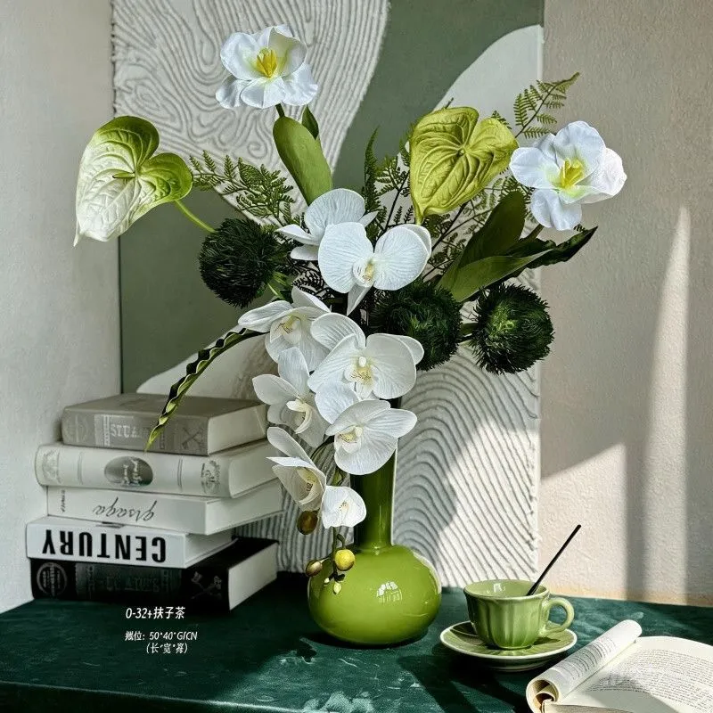 Künstliches Blumenarrangement mit dekorativer grüner Vase