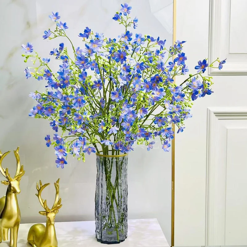 Künstliches Blumenarrangement mit dekorativer Glasvase