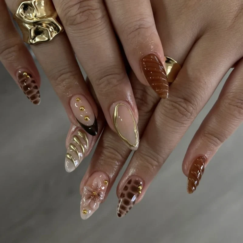 Kunstnägel im modernen Stiletto-Design mit goldenen Akzenten Karnz