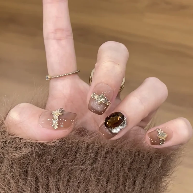 Künstliche Nagelkunst mit Glitzer- und Schmuckverzierungen Karnz