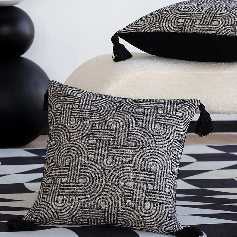 Quadratischer Kissenbezug aus strukturierter Bouclé‑Webung mit geometrischem Relief und Eckquasten Karnz