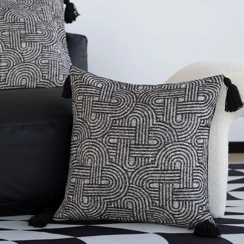 Quadratischer Kissenbezug aus strukturierter Bouclé‑Webung mit geometrischem Relief und Eckquasten Karnz
