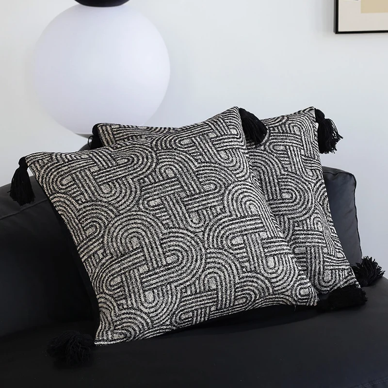 Quadratischer Kissenbezug aus strukturierter Bouclé‑Webung mit geometrischem Relief und Eckquasten Karnz