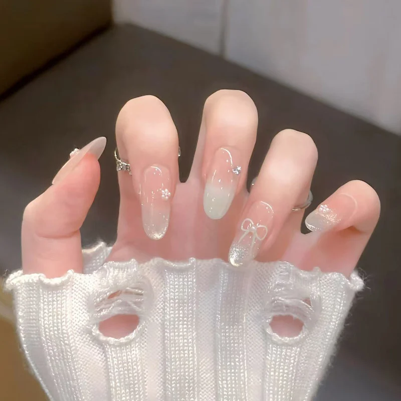 Dekorative Press-On Nagelkunst mit Schleifen- und Edelsteinakzenten Karnz