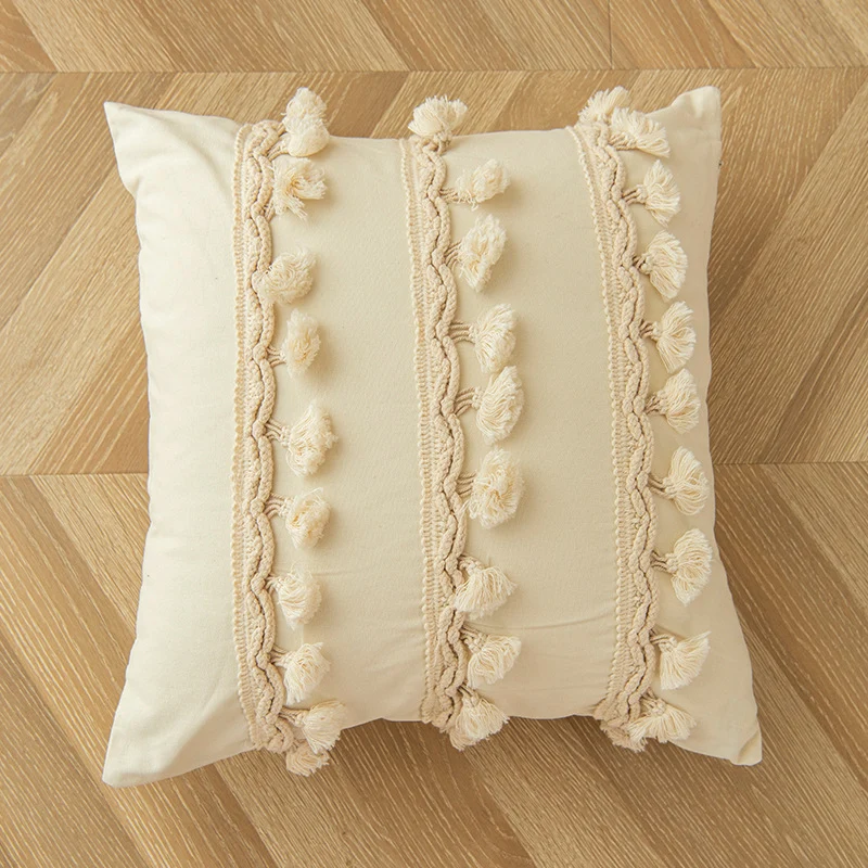 Dekoratives Kissen mit Quastenbesatz, quadratisch, mit Pomponreihen und geflochtenen Baumwollakzenten