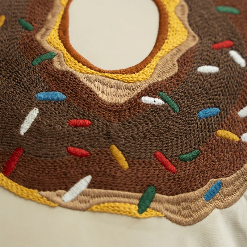 Quadratischer dekorativer Kissenbezug mit handgestickter Donut‑Applikation und Keder Karnz