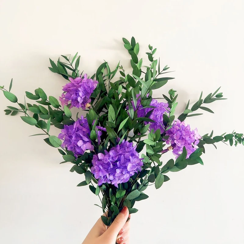 Lebensechter Blumenstrauß mit grünen Blättern