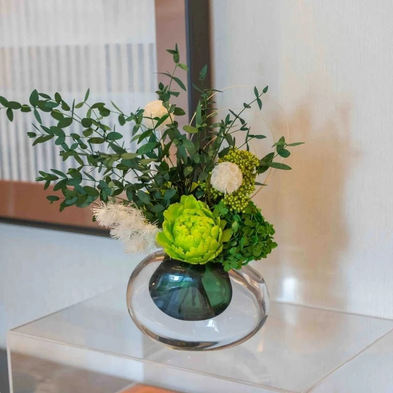 Lebensechte Blumenarrangement mit Glasvase