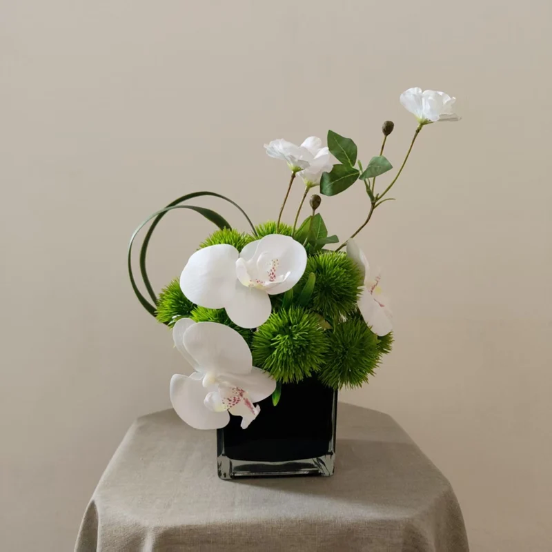 Lebensechte Orchideen- und Grünpflanzen-Arrangement