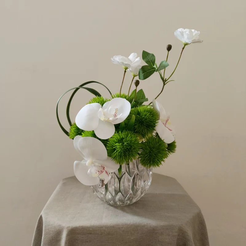Lebensechte Orchideen- und Grünpflanzen-Arrangement