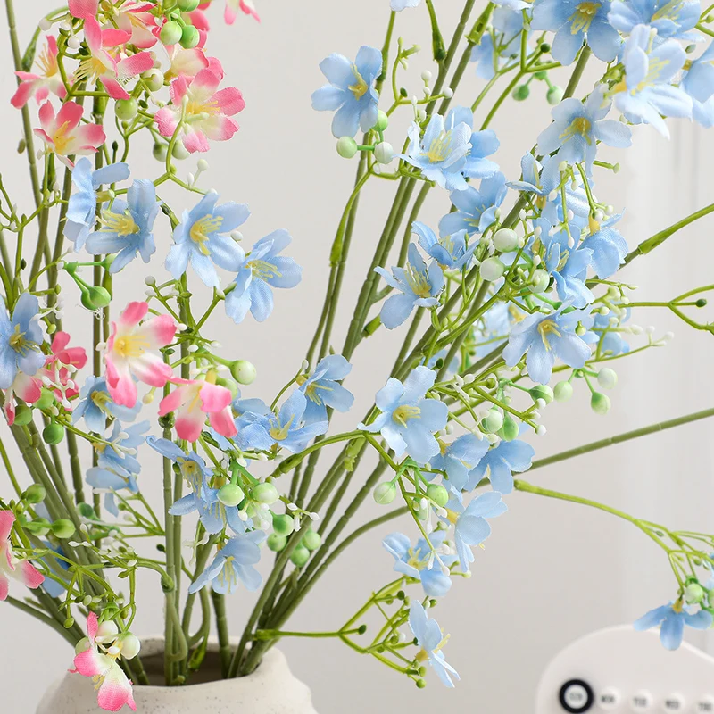 Künstlicher Blütenzweig mit zarten blauen Blumen und grünen Beeren Karnz