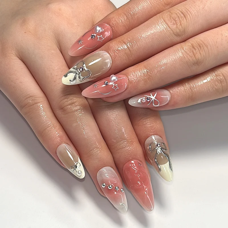 Kunstvolle Nagelspitzen mit Glitzer- und Schleifenmotiven Karnz